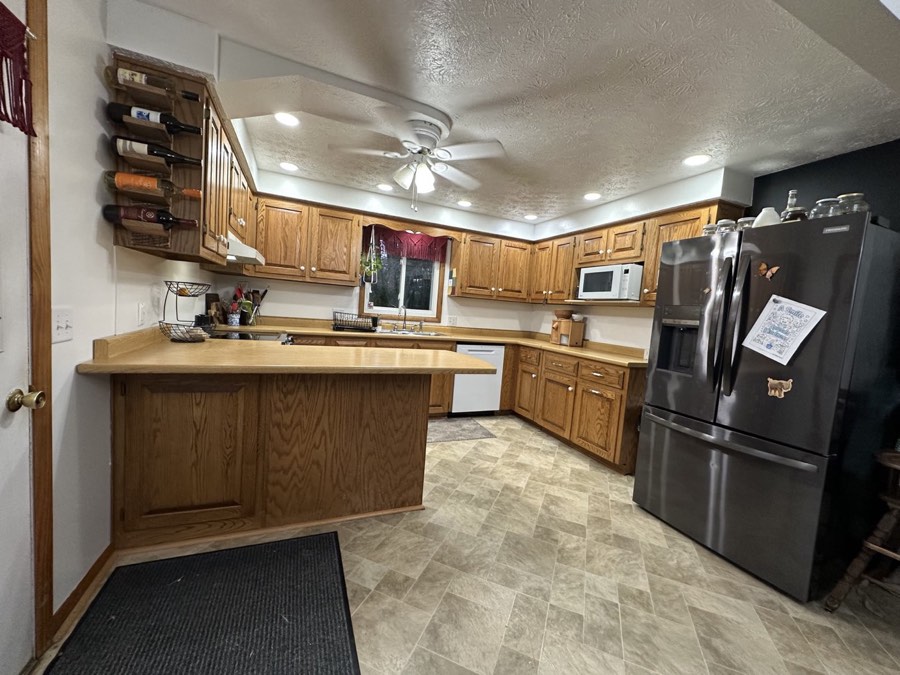 Kitchen with oak cabinetry and black-stainless appliances